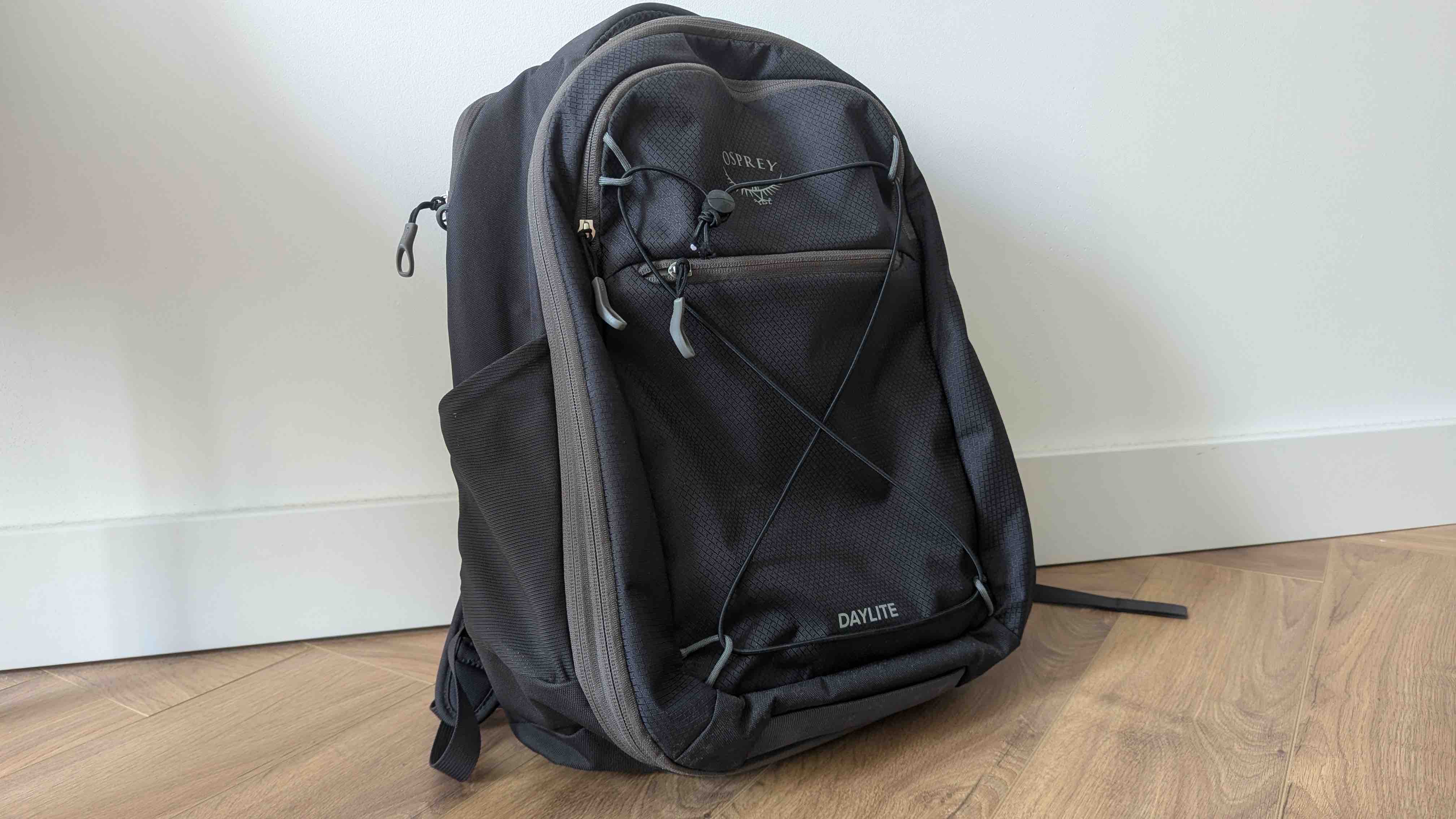 Osprey Daylite 26+6L black backpack, front view, standing against a white wall